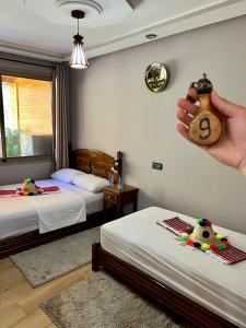 a person holding a clock in a room with two beds at Akchour waterfalls in Akchour