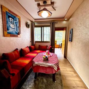 a living room with a red couch and a table at Akchour waterfalls in Akchour +4 photos