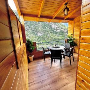 a room with a table and chairs on a balcony at Akchour waterfalls in Akchour