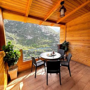a patio with a table and chairs on a balcony at Akchour waterfalls in Akchour