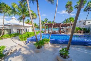 a resort with a swimming pool and palm trees at Alquimia Hotel Boutique in Tulum