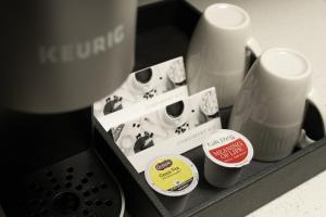 a group of coffee cups and a coffee machine at Silver Cloud Hotel - Mukilteo Waterfront in Mukilteo