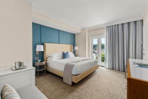 a hotel room with a bed and a couch at The Shepherd Hotel Downtown Clemson in Clemson