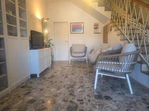 a living room with a couch and a chair and stairs at Two Palms Villa in Zaton