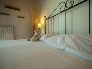 a teddy bear sitting on top of a white bed at Apartment Girasoli by Interhome in Brusasco