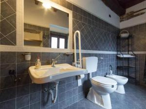 a bathroom with a sink and a toilet and a mirror at Apartment Girasoli by Interhome in Brusasco