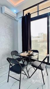 a dining table and chairs in a room with a window at Le Cocooning Mermoz-Batrain in Dakar