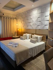 a bedroom with a large bed in a room at Hotel Arlen in Pouso Alegre