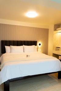 a bedroom with a large white bed with a black headboard at Solay Inn in Ayacucho