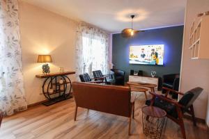 a living room with chairs and a table at Gîte les Lilas Blancs 15mn Gérardmer in Champdray