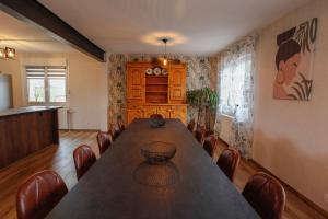 a dining room with a long table and chairs at Gîte les Lilas Blancs 15mn Gérardmer in Champdray