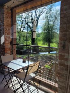 a table and two chairs on a balcony with a window at La Filature 1813 in Wasselonne