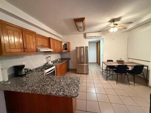 a kitchen with wooden cabinets and a table and a dining room at Ideal beach getaway in Nenúfares 2-101 in Nuevo Vallarta