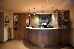 a woman sitting at a bar in a restaurant at Resort Hotel Zvíkov in Zvíkovské Podhradí +37 photos