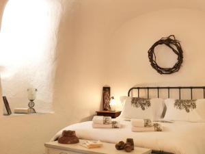 a bedroom with a bed with white sheets and a mirror at AFOURA HOUSES by K&K in Pyrgos