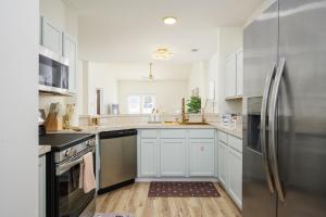 a kitchen with white cabinets and a stainless steel refrigerator at Casa Del Café in Bluffton