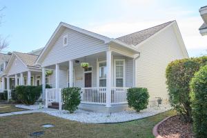 a white house with a porch and bushes at Casa Del Café in Bluffton