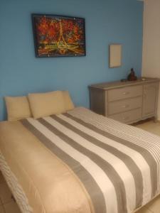 a bedroom with a bed with a painting on the wall at Casa Altamirano in La Paz +1 photo
