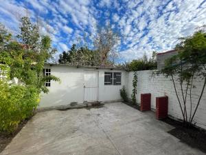 a white building with a gate and a fence at Casa Altamirano in La Paz