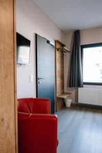 a living room with a red chair and a door at Gasthaus SEPP in Dernau +42 photos