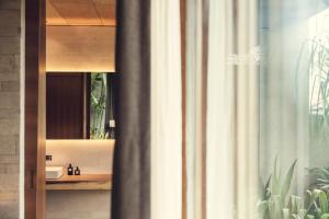 a bathroom with a sink and a shower curtain at The Slow in Canggu +50 photos
