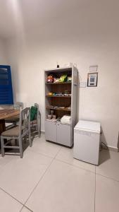 a white room with a table and a refrigerator at Casa Colina in Ouro Preto