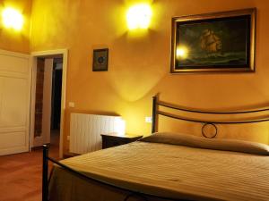 a bedroom with a bed and a picture on the wall at Apartment Wohnung Leccio by Interhome in Castagneto Carducci
