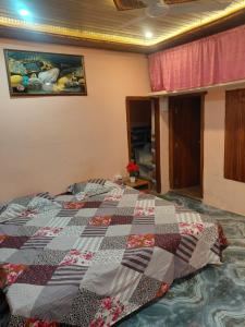 a bed in a room with a quilt on it at The Heaven Town in Hawālbāgh