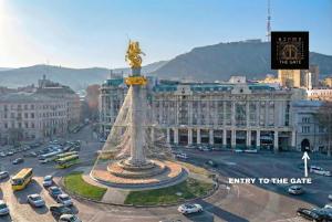 a city with a statue in the middle of a street at The Gate Hotel City Centre in Tbilisi City