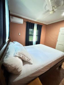 a bedroom with a white bed with a window at Riverside Lodge Bansang in Bansang