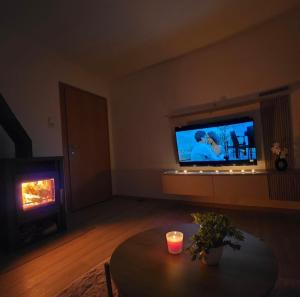 a living room with a table and a tv and a fireplace at Apartment AlpenHerz Trieben in Trieben
