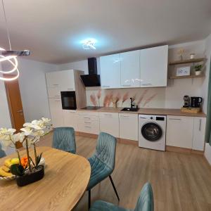 a kitchen with a table and chairs and a kitchen with white cabinets at Apartment AlpenHerz Trieben in Trieben