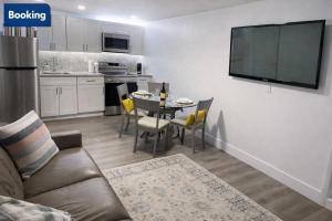 a living room with a couch and a tv on a wall at Modern Hard Rock Apartment in Miramar