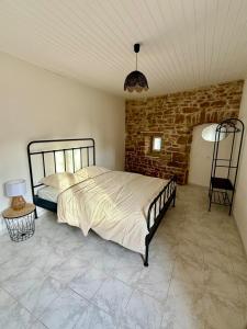 a bedroom with a bed and a brick wall at Gîte 2 suites proche du lac de Chalain in Montigny-sur-lʼAin