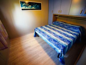 a bedroom with a bed with a blue comforter at Apartment Haus Jasmin by Interhome in Castagneto Carducci
