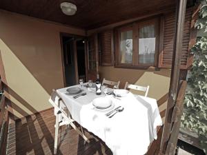 a table with a white table cloth on a porch at Apartment Haus Jasmin by Interhome in Castagneto Carducci