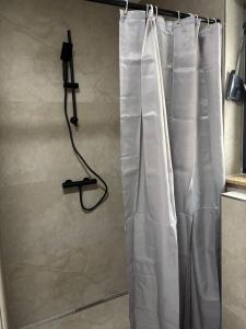 a shower with a white shower curtain in a bathroom at Ferienwohnung Mina in Münsingen