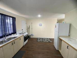 a kitchen with a white refrigerator and a sink at Lagoon House in Veitongo