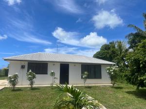 a white house with trees in front of it at Lagoon House in Veitongo