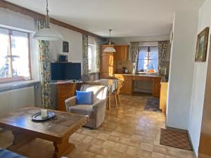 a living room with a table and a kitchen at Bauernhof Daurerhof Ferienwohnung in Aschau im Chiemgau