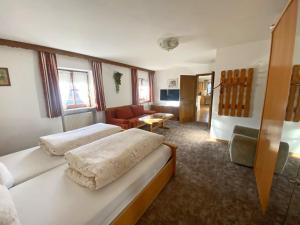 a hotel room with two beds and a living room at Bauernhof Daurerhof Ferienwohnung in Aschau im Chiemgau