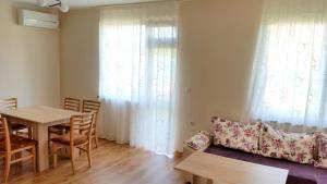 a living room with a table and a couch at Guesthouse River House in Svilengrad