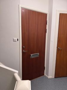 a wooden door in a room with a toilet at Asken 8 in Klippan