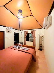 a bedroom with a large bed with a ceiling at Relaxbar&bungalow in Ko Phayam