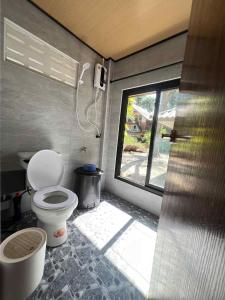 a small bathroom with a toilet and a window at Relaxbar&bungalow in Ko Phayam