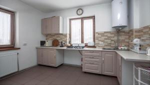 a kitchen with white cabinets and a counter top at Котедж "У Мадяра" in Mykulychyn