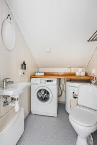 a bathroom with a washing machine and a sink at Skottinden Panorama Lofoten in Ballstad +32 photos