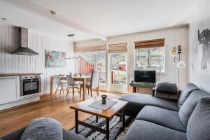 a living room with a couch and a table at Skottinden Panorama Lofoten in Ballstad