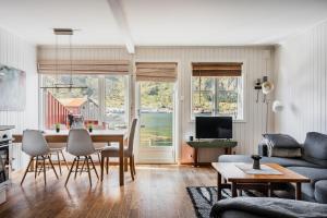 a living room with a table and chairs and a couch at Skottinden Panorama Lofoten in Ballstad
