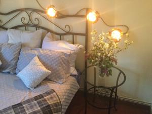 - une chambre avec un lit orné d'un vase de fleurs et de lumières dans l'établissement Casa Lola, à Pelegrina 13 autres photos